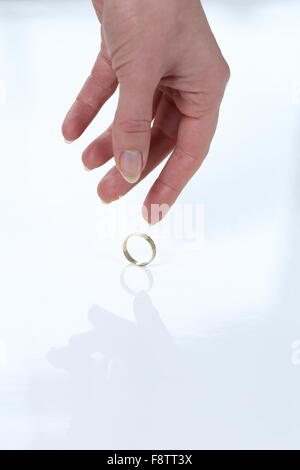 A Woman placing wedding ring on a table leaving her husband Stock Photo