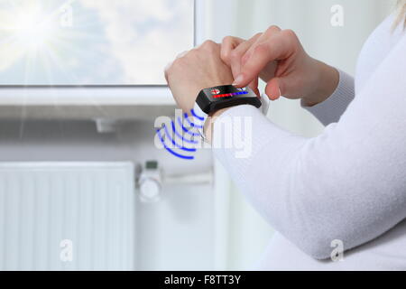 Adjusting room temparature with Smartwatch in a Smarthome Stock Photo