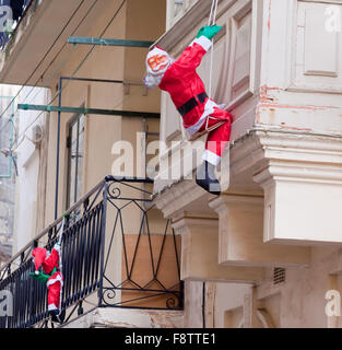 Santa Claus climbing up house wall at european town Stock Photo ...