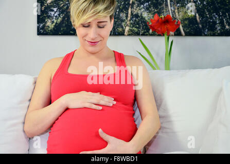 pregnant woman with twin babys, Hands on stomach listening Stock Photo