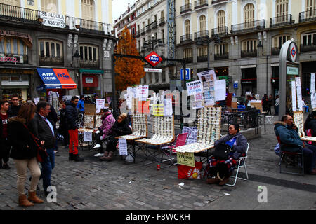 Madrid, Spain 11th December 2015: Lottery ticket sellers selling tickets for the Christmas Lottery next to an entrance to the Sol Metro station in Plaza Puerta del Sol in central Madrid. The Spanish Christmas Lottery is one of the oldest in the world and the biggest in the world in terms of total payout. The winning ticket is known as 'El Gordo' ('The Big One' or 'The Fat One'). Credit:  James Brunker / Alamy Live News Stock Photo