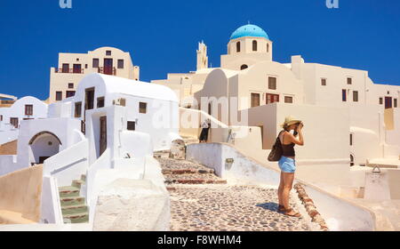 Santorini Caldera, Greece - tourist takes pictures of Oia houses, Cyclades Islands, Greece Stock Photo