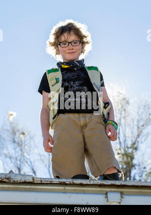 Eight-year-old boy climbing on old rail train car Stock Photo