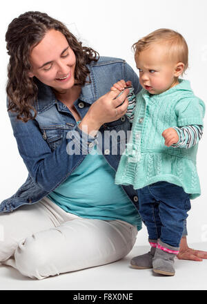 Studio photograph of young Caucasian mother and cute one year old baby girl Stock Photo