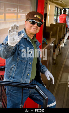 Friendly train conductor waves to passengers on train at Ibarra station that is headed to Salinas, Ecuador. Stock Photo
