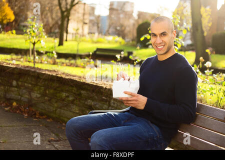 young man enjoying a take-away in the park Stock Photo