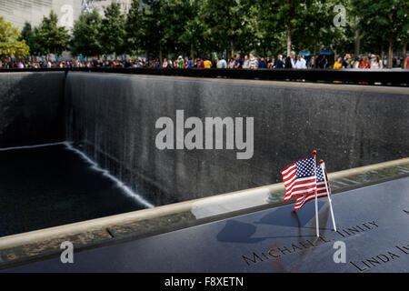 US flags placed on the name of a victim of terrorist attack on the National 9/11 Memorial, New York City, USA Stock Photo