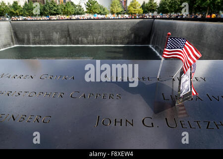 US flag and photography placed on the name of a victim of terrorist attack on the National 9/11 Memorial, New York City, USA Stock Photo