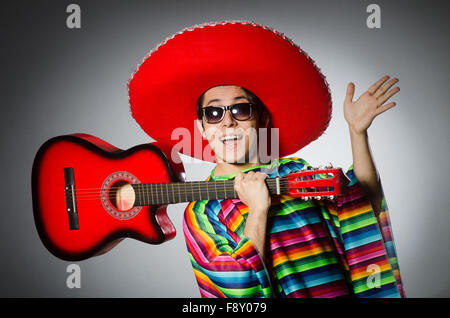 Man in red sombrero playing guitar Stock Photo