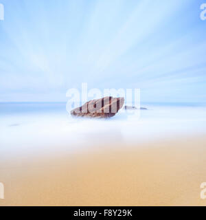 Rock, sea and gold sand seascape. Seven minutes long exposure photography. Italy Stock Photo