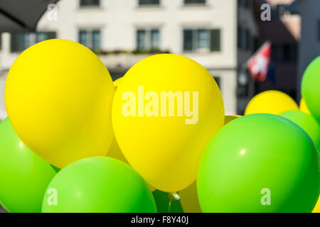 Bright yellow and green balloons on a city street event in summer Stock Photo