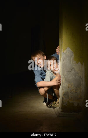 Little boys in a dark cellar Stock Photo