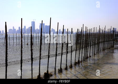 View of Manama, taken from behind fishing nets at Bu Maher Fort, Muharraq,  Kingdom of Bahrain Stock Photo