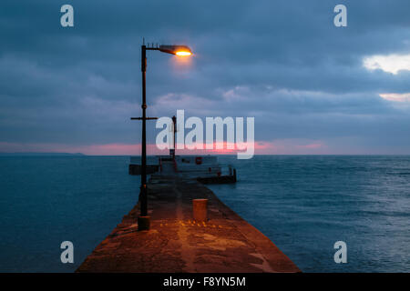 First light of a new day falling over the Banjo Pier in East Looe Cornwall Stock Photo