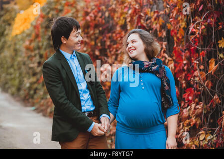 Pregnant smiling couple walking in the park Stock Photo