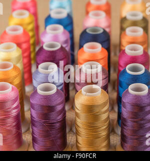 Spools of colorful embroidery thread in rows. Stock Photo