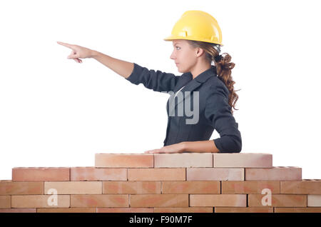 Young female builder near brick wall Stock Photo