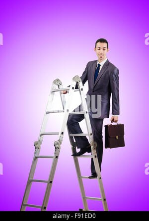 Businessman climbing career ladder against gradient Stock Photo