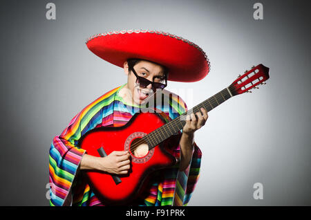 Man in red sombrero playing guitar Stock Photo