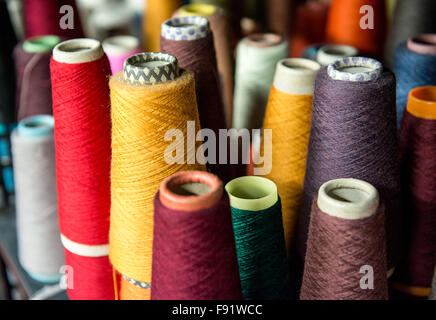 Colorful assortment of vivid colors of cotton spools on cardboard cones for use in the knitwear and garment industry viewed high Stock Photo