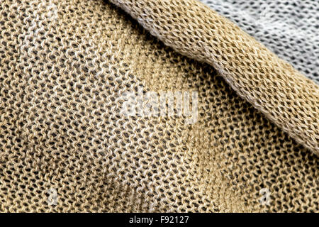 Abstract Textile Background - Detail of Metallic Gold Knit Fabric Layered with White Knit in Background Stock Photo