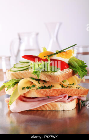 Ham and cheese sandwich garnished with fresh vegetables Stock Photo