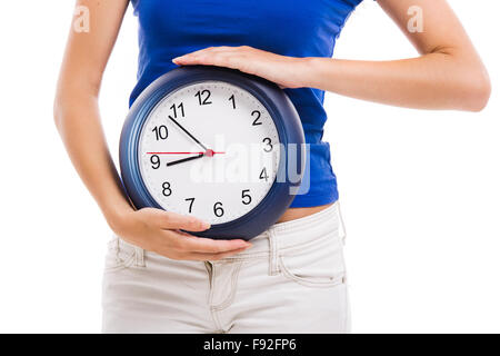 Causal young woman holding a clock, isolated over a white background Stock Photo