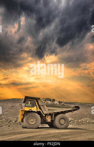 Heavy mining truck loaded with iron ore on sunset Stock Photo