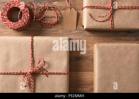 Christmas presents wrapped with eco friendly and recyclable paper and cord. High angle closeup in horizontal format. Stock Photo