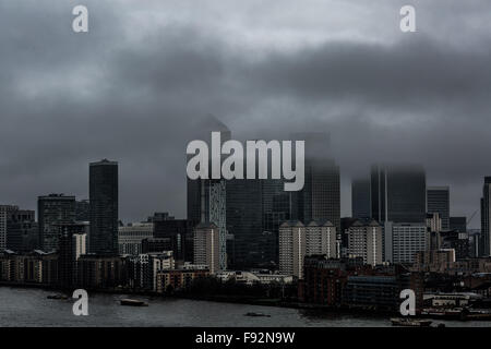 London, UK. 13th December, 2015. UK Weather: Afternoon fog clouds over Canary Wharf business park buildings and River Thames Credit:  Guy Corbishley/Alamy Live News Stock Photo