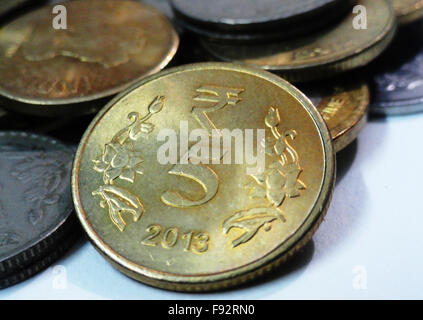 Five Rupees Indian Golden Coin and Other Coins Stock Photo