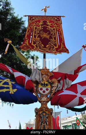 Colourful Maltese national and village flags on lamp post for an annual Saints day Festa, or feast day, celebration and party Stock Photo