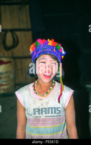 Young girl from a Burmese hill tribe near Kalaw, Myanmar, wearing a blue hand-made hat with pom-poms sold as a tourist souvenir Stock Photo