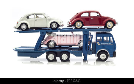 Three Vintage VW Beetles  on a car Transporter on a white background. Stock Photo
