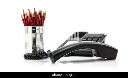 Black office telephone isolated on a white background with tin on red pencils Stock Photo