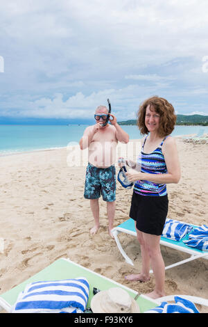 A 50 year old Caucasian couple prepare to go snorkeling in the Caribbean sea in St. Croix, U.S. Virgin Islands. Stock Photo
