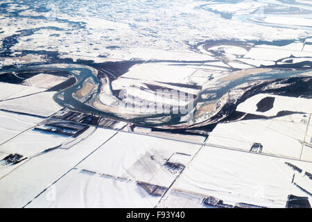 Aerial view of snow covered prairie landscape with meandering river, floodplain and farm land in winter, Saskatchewan Stock Photo