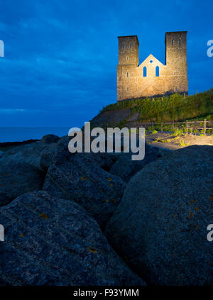 The twin towers of St. Mary's Church, Reculver on the north Kent coast, illuminated at dusk. Stock Photo