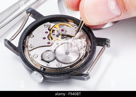 adjusting old mechanic wristwatch - horologist repairs old watch close up Stock Photo