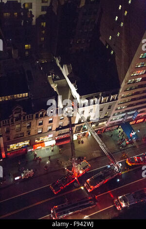 New York, USA. 13th December, 2015. Hook and ladder trucks are on the scene with firemen on top of a brownstone building. Credit:  Patti McConville/Alamy Live News Stock Photo