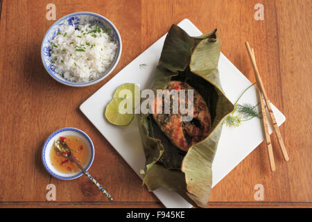 Roasted Salmon in Banana Leaves, spicy dill and lime paste, coconut rice, Vietnamese dipping sauce, peppers, Stock Photo