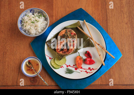 Roasted Salmon in Banana Leaves, spicy dill and lime paste, coconut rice, Vietnamese dipping sauce, peppers, Stock Photo