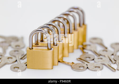 Several locks in a row with keys on white background Stock Photo