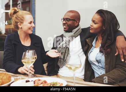 Good friends enjoying dinner outside on a cafe, ethnic friends Stock Photo