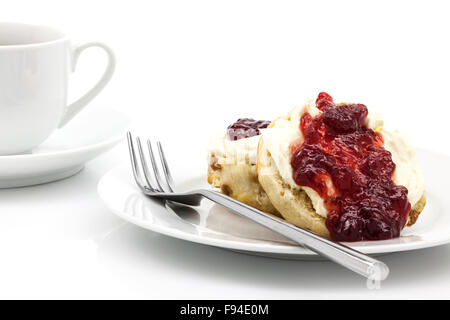 Home-baked scones with strawberry jam and clotted cream, often served with a cup of tea. Known as a cream tea. Stock Photo