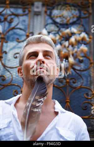 Sexi Man in a white shirt and ornamental window on background. And Dream Catcher. Stock Photo