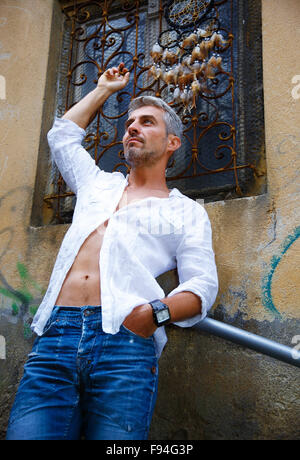 Sexi Man in a white shirt and ornamental window on background. And Dream Catcher Stock Photo