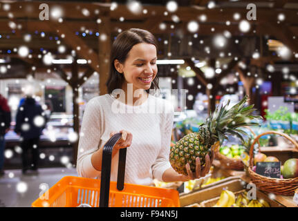 happy woman with food basket in grocery store Stock Photo
