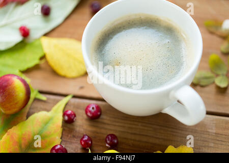 close up of coffee cup on table with autumn leaves Stock Photo