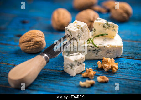 Blue cheese with nuts on blue wooden table Stock Photo